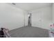 Bright bedroom featuring gray carpet, a dual door, and neutral walls at 10986 W Polk St, Avondale, AZ 85323