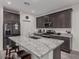Spacious kitchen with a large island featuring granite countertops and dark cabinets at 10986 W Polk St, Avondale, AZ 85323