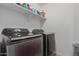 Convenient laundry room with side-by-side washer and dryer and storage shelves at 10986 W Polk St, Avondale, AZ 85323