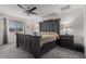 Elegant main bedroom featuring a dark wood sleigh bed, plush carpet, and a ceiling fan at 10986 W Polk St, Avondale, AZ 85323