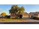 Charming single-story home featuring a well-maintained lawn, mature trees, and a two-car garage at 11265 E Contessa St, Mesa, AZ 85207