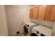 Convenient laundry room with updated washer and dryer and ample storage cabinets above machines at 11265 E Contessa St, Mesa, AZ 85207