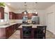 Well-lit kitchen with stainless steel appliances, an island, and wooden cabinetry at 11454 W St John Rd, Surprise, AZ 85378