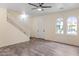 Spacious living room featuring tile flooring, a staircase, and arched windows at 11454 W St John Rd, Surprise, AZ 85378