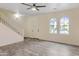 Open living room featuring tile flooring, a staircase, and arched windows at 11454 W St John Rd, Surprise, AZ 85378