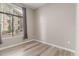 Bright bedroom featuring neutral walls, wood-look floors, and a large window with blinds and curtains at 11640 N Tatum Blvd # 1031, Phoenix, AZ 85028