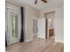 Bright bedroom featuring neutral walls, wood-look floors, a glass door and two doors to a walk-in closet and bathroom at 11640 N Tatum Blvd # 1031, Phoenix, AZ 85028