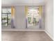 Bright living room with natural light, wood-look floors, and stylish modern window treatments at 11640 N Tatum Blvd # 1031, Phoenix, AZ 85028