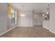 Bright living room with wood-look floors, modern light fixture, and combined kitchen area at 11640 N Tatum Blvd # 1031, Phoenix, AZ 85028