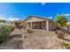 A charming home with a large covered patio surrounded by serene desert landscaping and a fenced yard at 12335 W Rosewood Ln, Peoria, AZ 85383