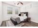 Cozy bedroom with wood floors, ceiling fan, window with shutters, and geometric side table at 12335 W Rosewood Ln, Peoria, AZ 85383