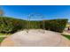 Manicured green lawn with a circular concrete pad and iron archway enveloped by a manicured privacy hedge at 12335 W Rosewood Ln, Peoria, AZ 85383