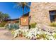 Kiva Club building featuring stone architecture, vibrant flowerbeds, and desert landscaping at 12335 W Rosewood Ln, Peoria, AZ 85383