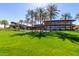 Exterior shot of the clubhouse situated on a lush green lawn dotted with palm trees at 12335 W Rosewood Ln, Peoria, AZ 85383