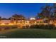 Exterior view of a well-lit clubhouse with palm trees and manicured landscaping at 12335 W Rosewood Ln, Peoria, AZ 85383