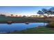 Scenic golf course view with a pond and lush green fairways at sunset at 12335 W Rosewood Ln, Peoria, AZ 85383