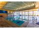 Indoor swimming pool with multiple lanes, ample lighting, and inviting lounge area for relaxation at 12335 W Rosewood Ln, Peoria, AZ 85383