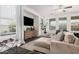 Bright living room featuring dark floors, many windows, and a sectional couch at 12335 W Rosewood Ln, Peoria, AZ 85383