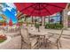 Charming outdoor seating area with red umbrellas, flowers, and lush green landscaping at 12335 W Rosewood Ln, Peoria, AZ 85383