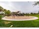 Community playground with swings and play structures surrounded by green grass at 12335 W Rosewood Ln, Peoria, AZ 85383