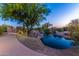 Scenic pond with rocks and lush desert landscaping featuring walking paths at 12335 W Rosewood Ln, Peoria, AZ 85383