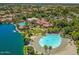 Aerial shot of Val Vista Lakes community featuring clubhouse, pool, sandy beach, and lush landscapes at 1414 N Palmsprings Dr, Gilbert, AZ 85234
