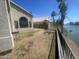 Backyard overlooking the water, featuring fencing, grass, and gravel areas at 1414 N Palmsprings Dr, Gilbert, AZ 85234