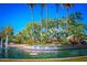 Entrance to Val Vista Lakes with lush landscaping, a water fountain, and palm trees under a blue sky at 1414 N Palmsprings Dr, Gilbert, AZ 85234