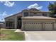 Exterior of the home with a three-car garage and landscaped front yard at 1414 N Palmsprings Dr, Gilbert, AZ 85234