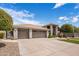 This home features a three-car garage, desert landscaping, and a tile roof at 15645 S 17Th St, Phoenix, AZ 85048