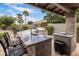 Outdoor kitchen showcasing granite countertops, a stainless steel grill, and bar seating for entertaining at 15645 S 17Th St, Phoenix, AZ 85048