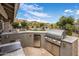 Outdoor kitchen area complete with stainless steel grill, mini fridge, and ample counter space at 15645 S 17Th St, Phoenix, AZ 85048