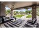 Covered patio featuring stone columns, ceiling fan, and a comfortable seating area overlooking the lush backyard at 15645 S 17Th St, Phoenix, AZ 85048