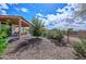 Well-maintained backyard with gravel landscaping, a charming patio area, and mature trees at 16445 W Berkeley Rd, Goodyear, AZ 85395