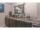 A stylish bar area featuring granite countertops, custom cabinetry, and a decorative mirror at 16445 W Berkeley Rd, Goodyear, AZ 85395