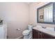 Powder room featuring decorative mirror, toilet, and vanity with stylish fixtures at 16445 W Berkeley Rd, Goodyear, AZ 85395
