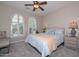 Bright bedroom features a ceiling fan, two arched windows with shutters, and a comfortable bed at 16445 W Berkeley Rd, Goodyear, AZ 85395