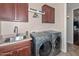 Well-equipped laundry room featuring a sink, washer, dryer, and upper cabinets at 16445 W Berkeley Rd, Goodyear, AZ 85395
