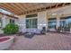 Charming patio featuring a comfortable seating area, fire pit, and stylish brick paving under a pergola at 16445 W Berkeley Rd, Goodyear, AZ 85395