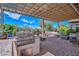 Beautiful outdoor patio with a built-in grill, fountain, and comfortable seating under a pergola at 16445 W Berkeley Rd, Goodyear, AZ 85395