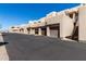 Sand-colored townhome complex with private garages and stairway access to upper units set against a clear blue sky at 16626 E Westby Dr # 108, Fountain Hills, AZ 85268