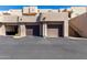 Exterior view of the garages with brown doors and desert landscaping with blue skies at 16626 E Westby Dr # 108, Fountain Hills, AZ 85268