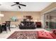 Open-concept living room featuring a leather sofa, bright ottoman, and a sleek ceiling fan at 16626 E Westby Dr # 108, Fountain Hills, AZ 85268
