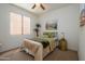 Comfortable bedroom featuring a window and an accent wall with elegant decorations at 17640 W Babbitt Dr, Surprise, AZ 85374