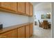 Hallway with wooden cabinets leading to a dining room at 17640 W Babbitt Dr, Surprise, AZ 85374