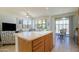 Open kitchen view with a large island, seating, and a view into the living room and backyard at 17640 W Babbitt Dr, Surprise, AZ 85374