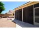 Back patio with a covered screened-in area including a small table and chair set for relaxation and comfort at 17640 W Babbitt Dr, Surprise, AZ 85374