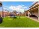 This backyard features a lush artificial turf lawn and a playground, perfect for outdoor fun and recreation at 17652 W Straight Arrow Ln, Surprise, AZ 85387