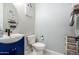 Stylish half bath featuring modern fixtures and light blue textured wallpaper at 17652 W Straight Arrow Ln, Surprise, AZ 85387