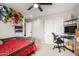 Comfortable bedroom with neutral walls, ceiling fan, and a study desk and toy storage shelves at 17652 W Straight Arrow Ln, Surprise, AZ 85387